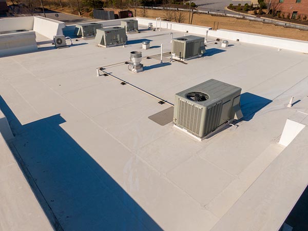 TPO-Roofing-Minot-ND-North-Dakota-2 | Hi-Line Commercial Roofing Rooftop view of multiple outdoor air conditioning units on a white flat roof with ducts and vents nearby
